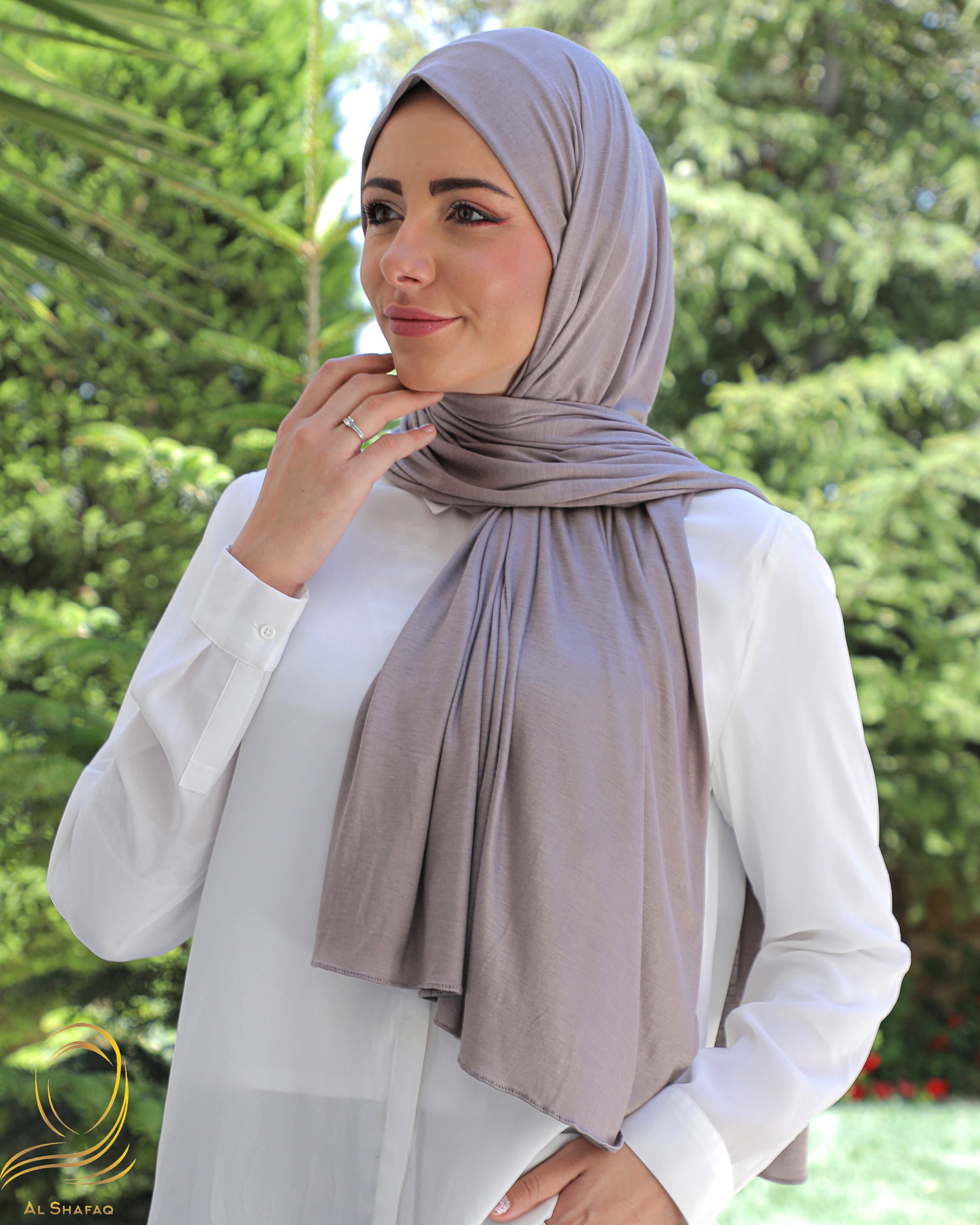 Front view of a smiling woman wearing a beige cotton hijab.