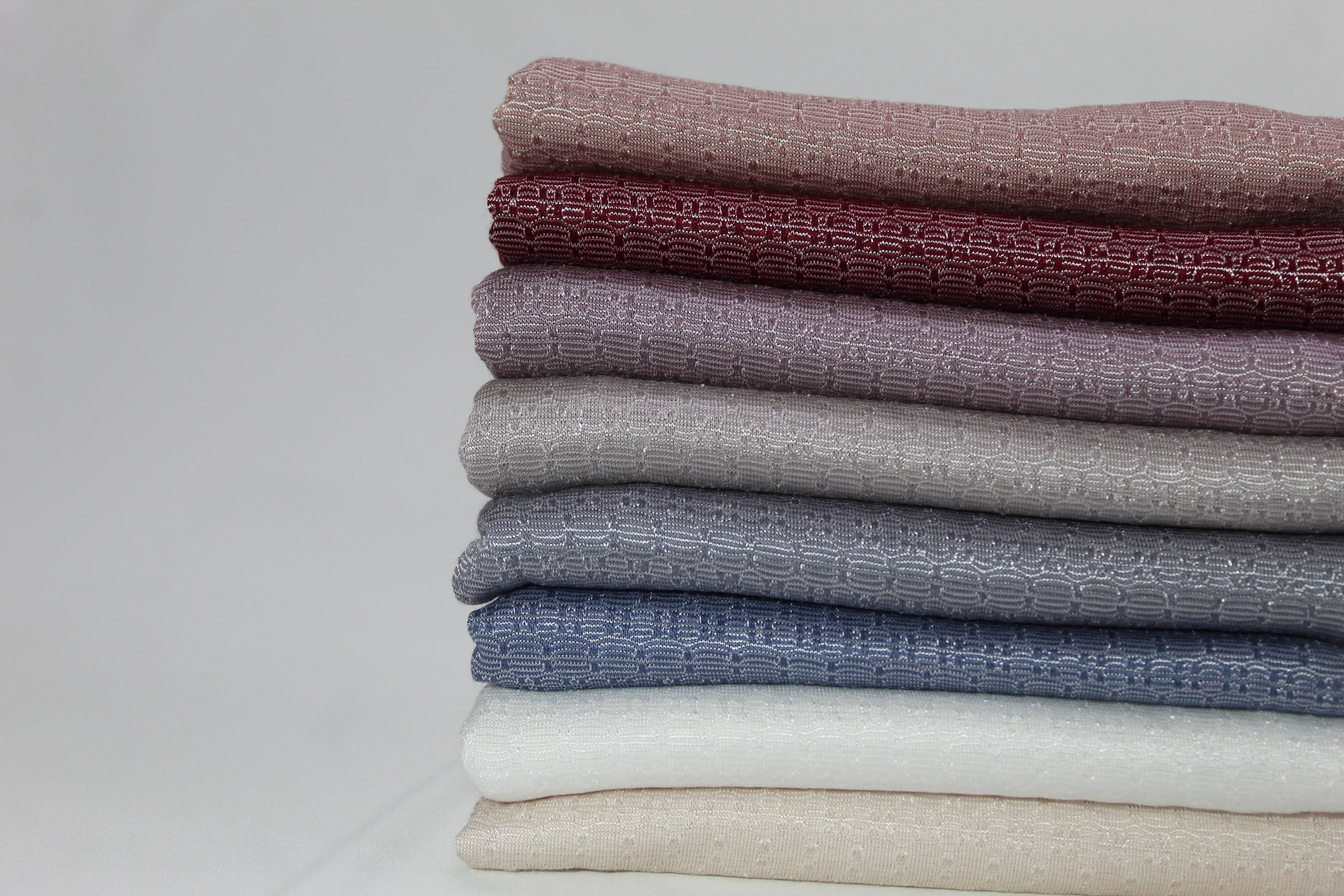 A close-up view of neatly folded hijabs in soothing shades, showcasing high-quality craftsmanship