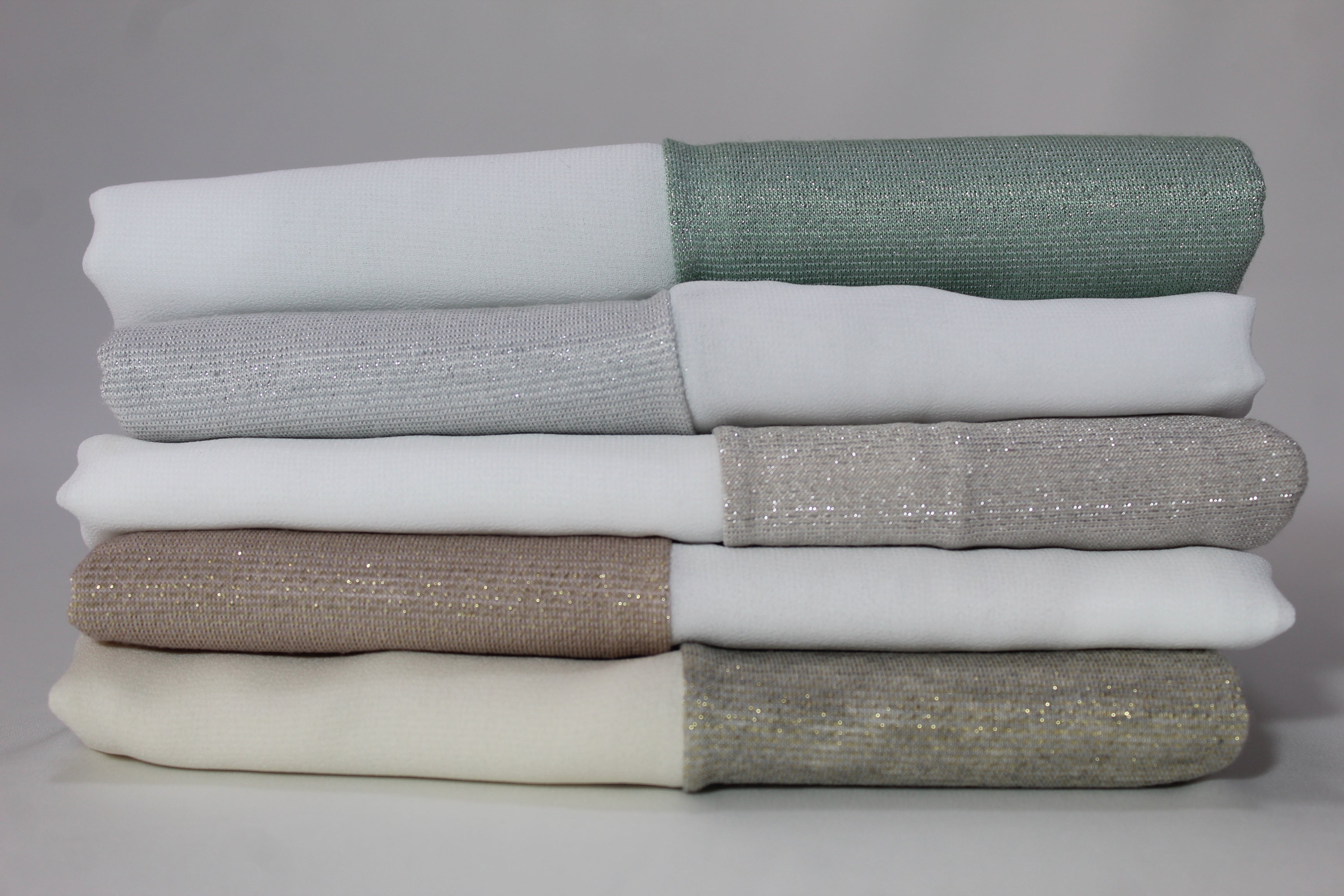 Stylish chiffon and lame hijabs with different colors stacked.