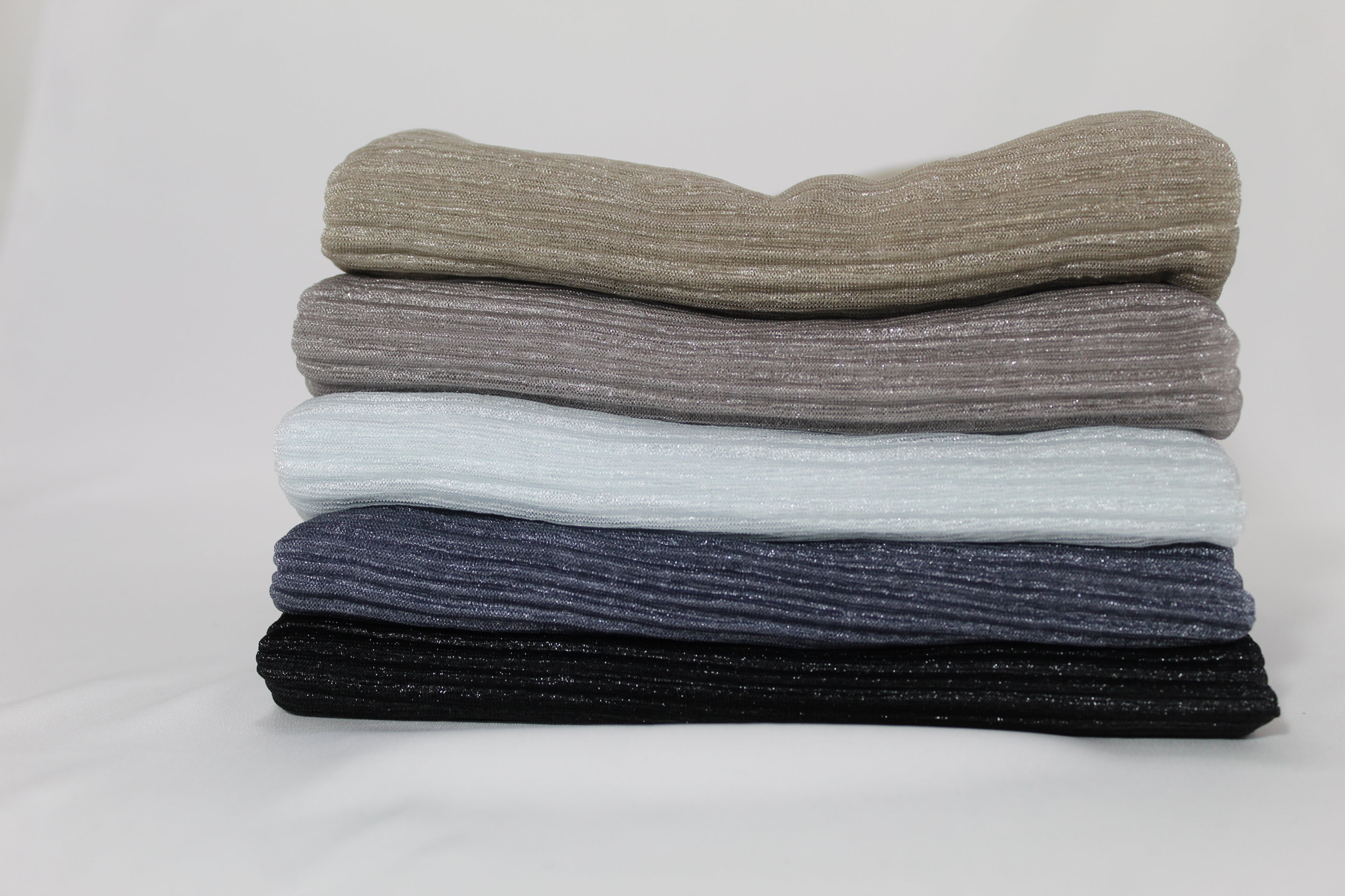 Four neutral-tone ribbed hijabs neatly folded in olive, gray, white, Dark blue,and black. Stylish, breathable hijabs for all-day wear