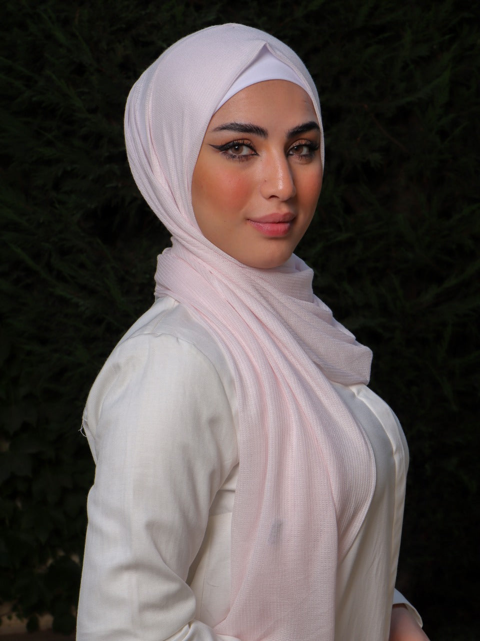 Model wearing a light pink hijab with clean lines and timeless style.
