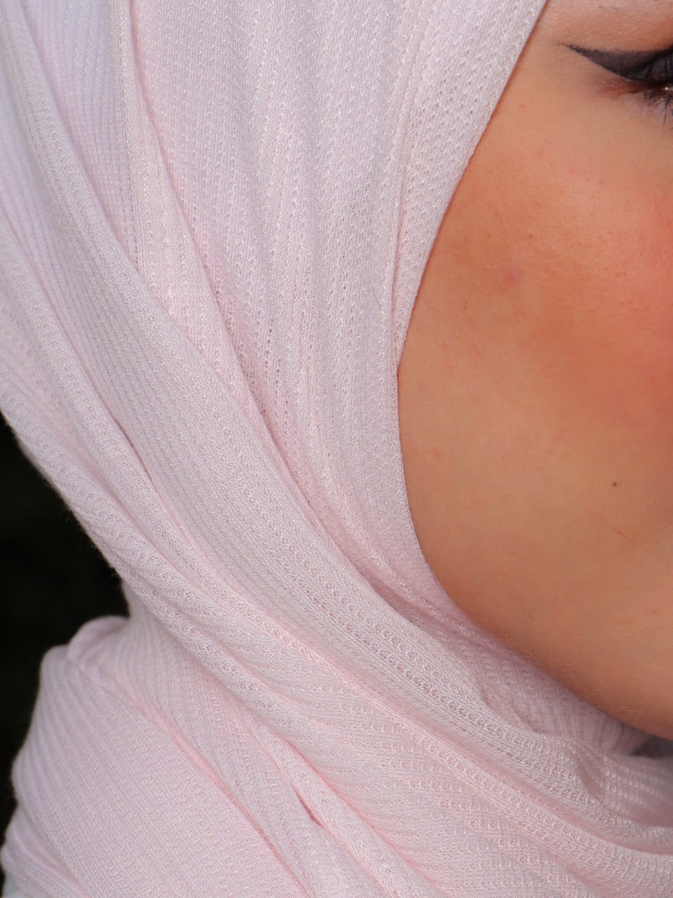Detailed side view of a soft pink hijab with smooth fabric and minimal design.
