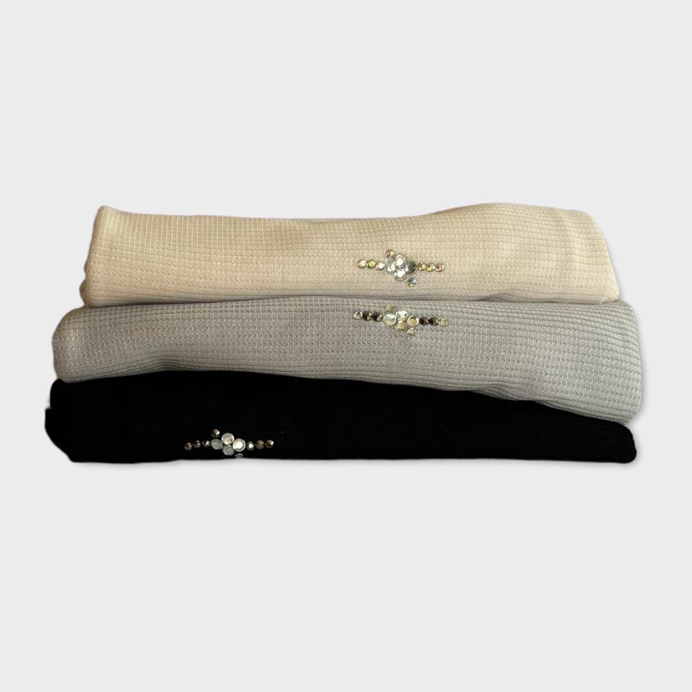 Folded hijabs with pearl and crystal embellishments in black, beige, and blush tones, adding a touch of elegance.