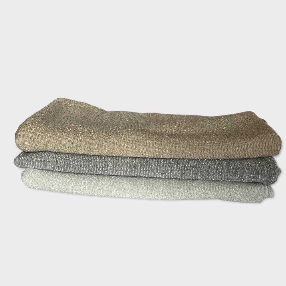 Stacked hijabs in earthy tones of taupe, olive green, and light beige, showcasing their natural texture