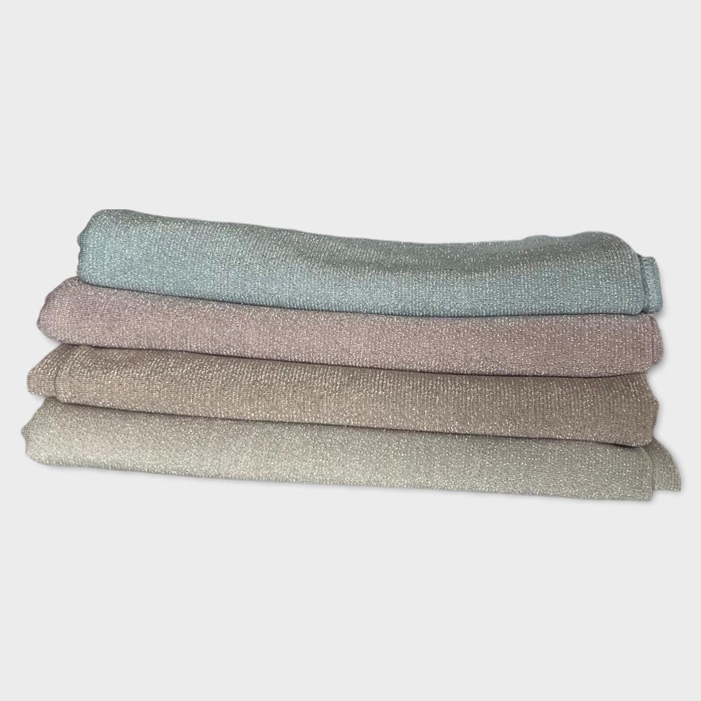 A set of folded hijabs in soft pastel colors, including mint green, beige, and blush pink