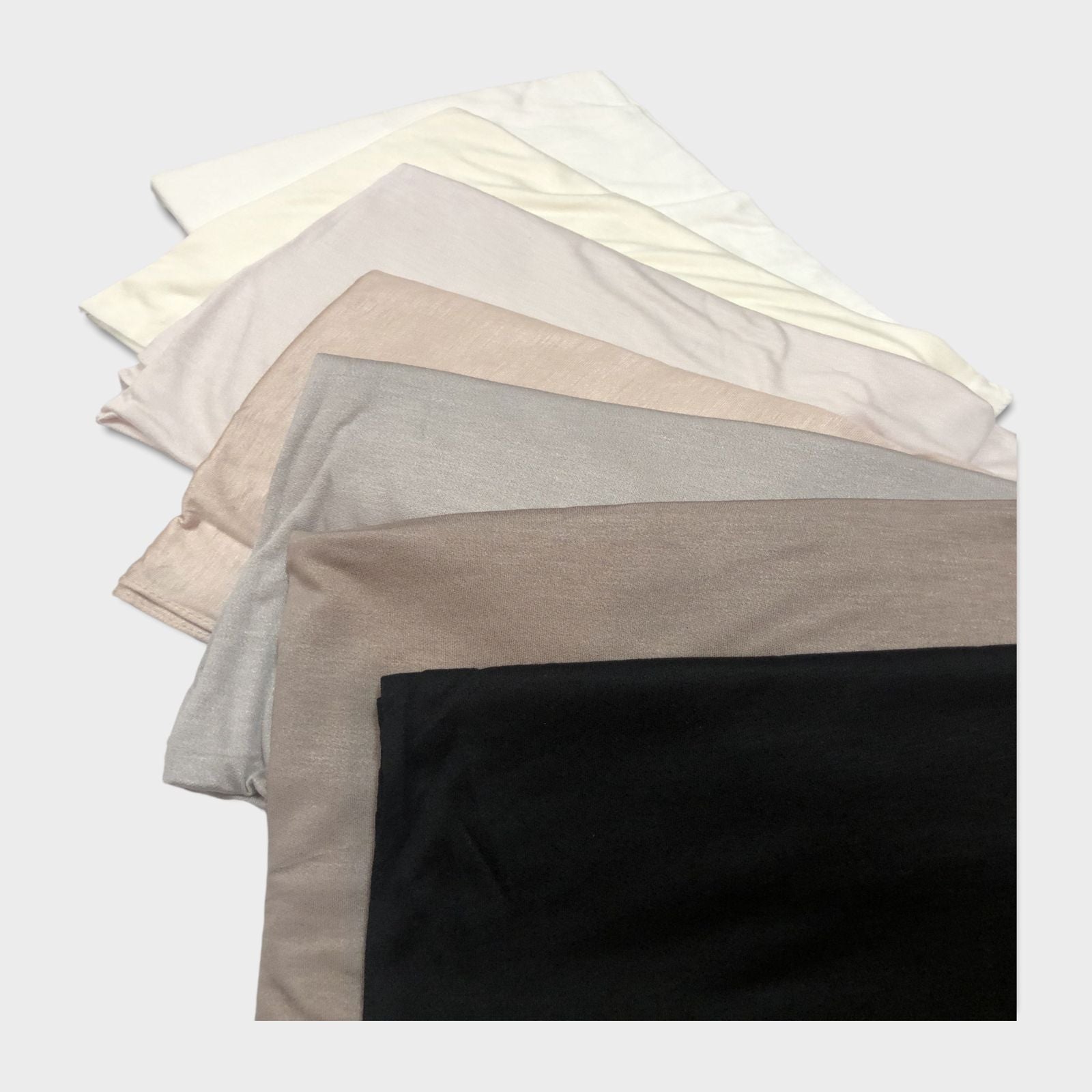 Assorted cotton hijabs in different colors, including beige, gray, white, offwhite, and black.