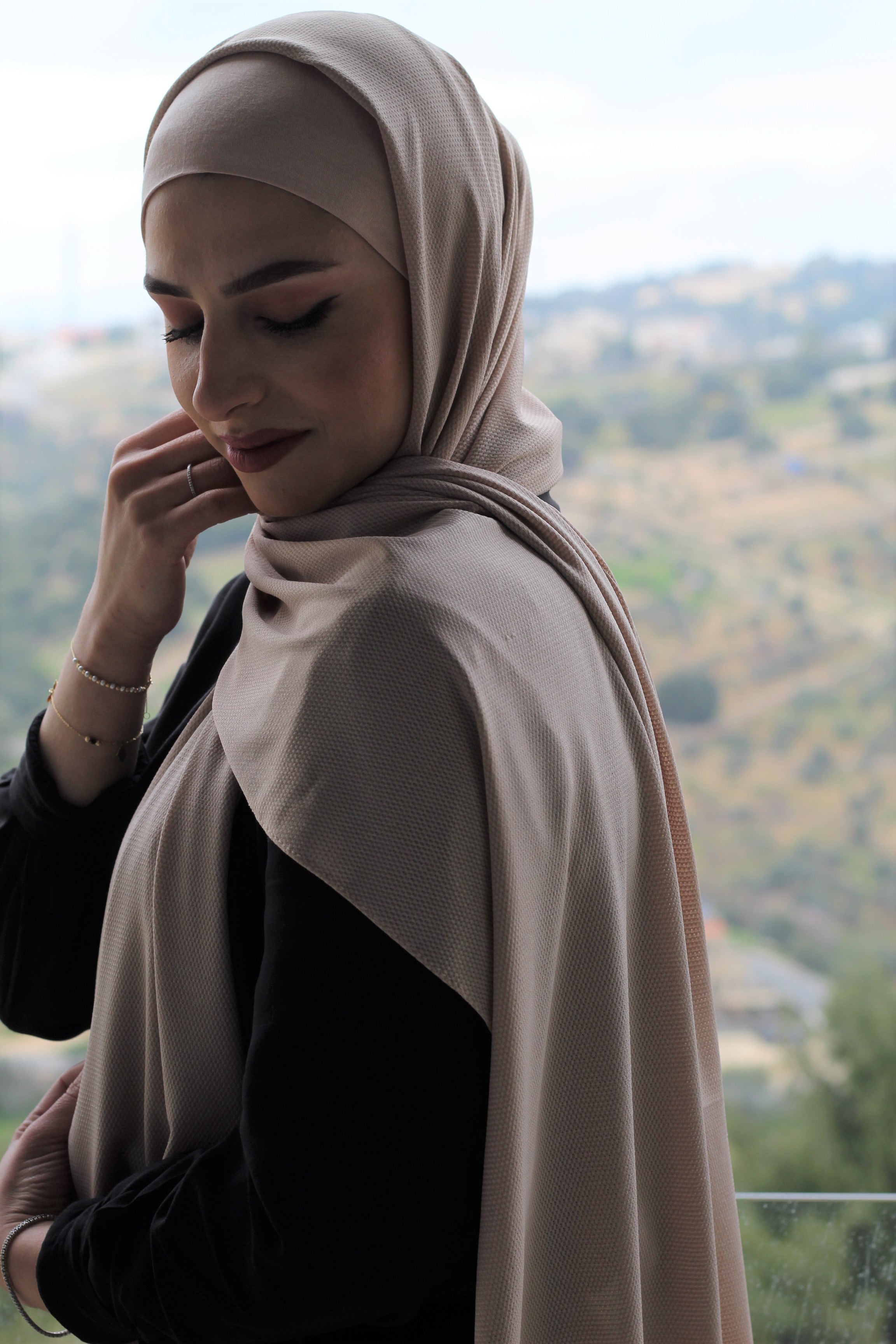 Model wearing a two-tone beige and black hijab, styled elegantly for both formal and casual settings.